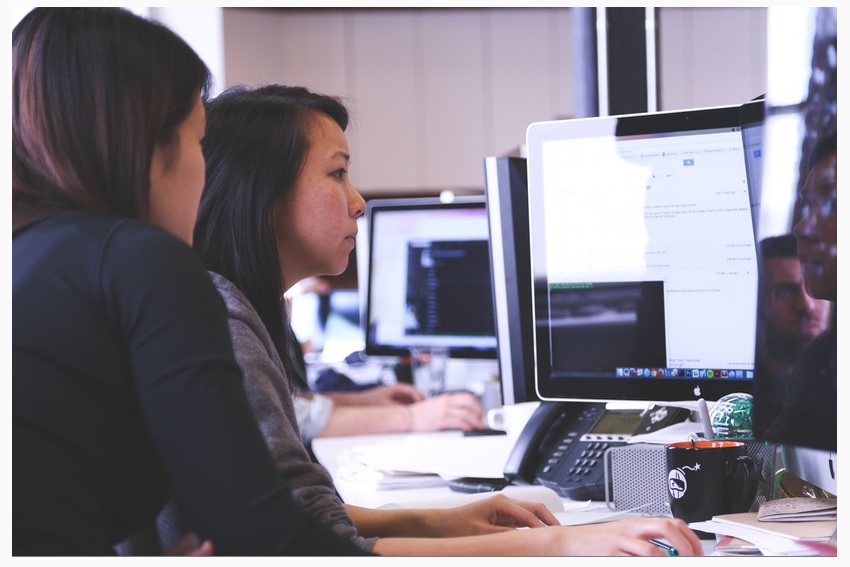 woman in front of computer learning how to use it with a facilitator