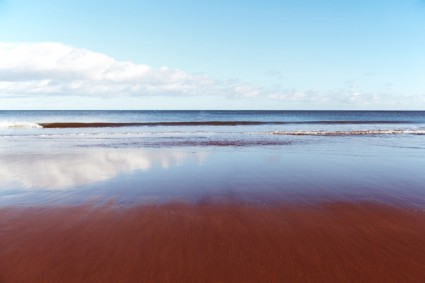 image of sky with ocean and waves breaking on the sand